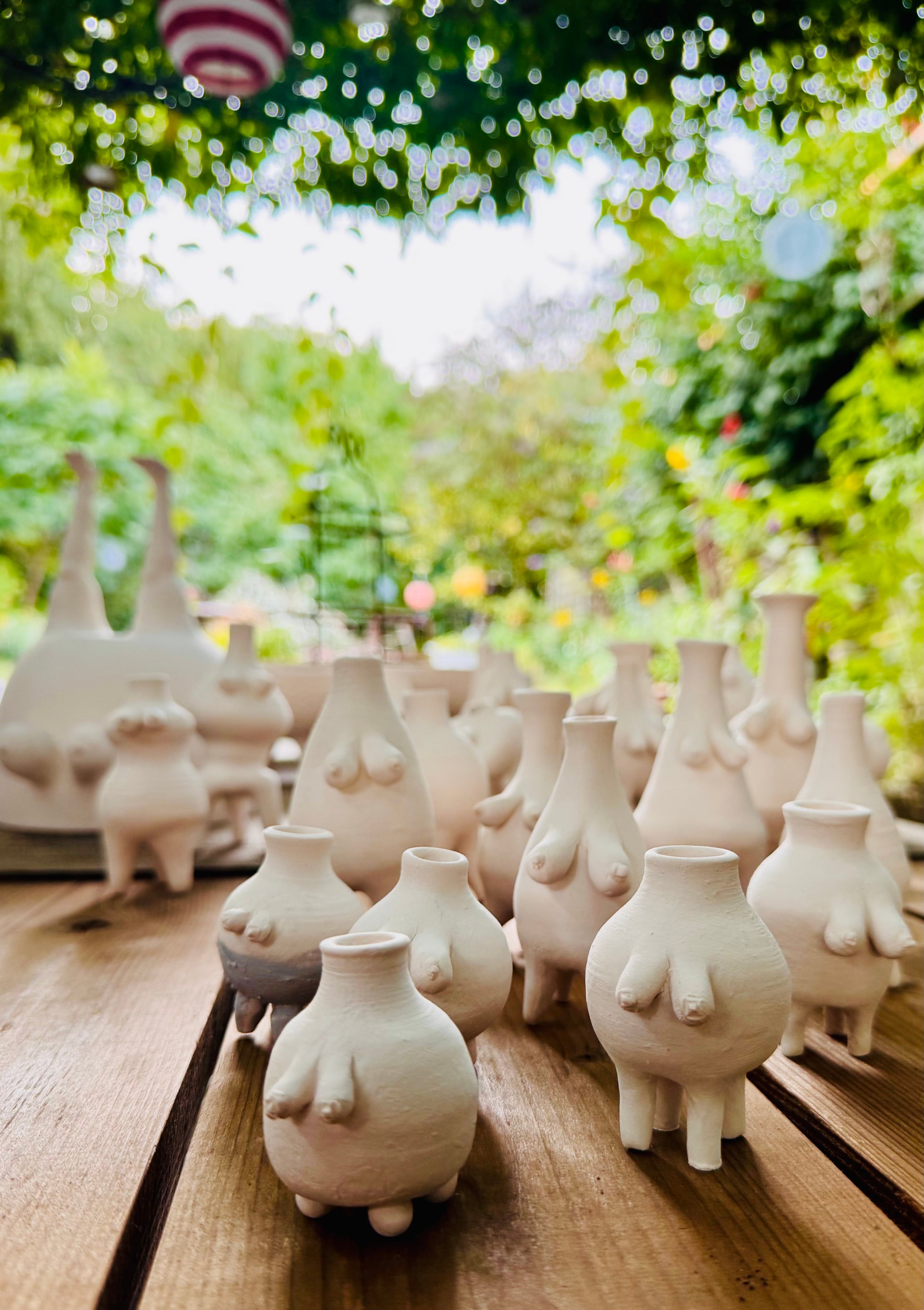 Witte mammavaasjes in de tuin van het atelier